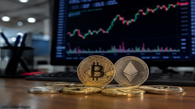 FTAsiaStock Crypto workspace featuring Bitcoin and Ethereum coins with a live cryptocurrency market chart on a trading monitor.